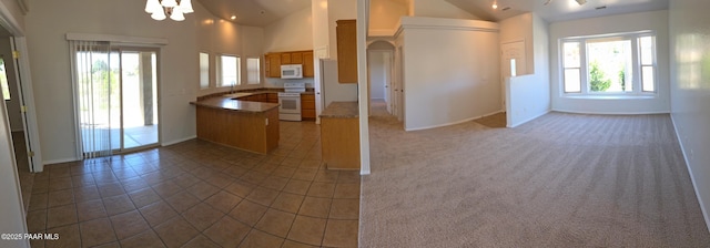 10919 E Roundup Dr, Dewey-Humboldt, AZ 86327 - kitchen featuring white appliances, open floor plan, a peninsula, plenty of natural light, and lofted ceiling