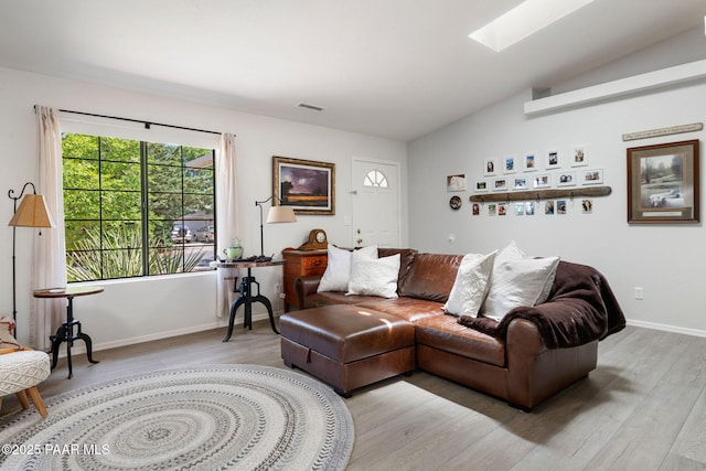 5420 N Mesquite Dr, Prescott Valley, AZ 86314 - living room featuring vaulted ceiling, light wood-style floors, a skylight, and baseboards