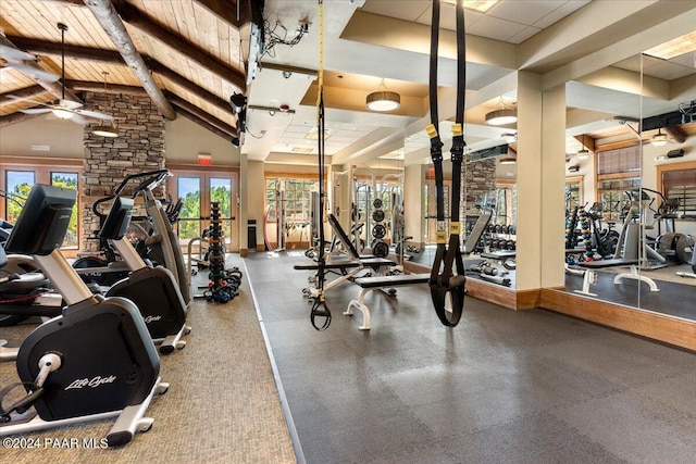 exercise room with high vaulted ceiling and ceiling fan