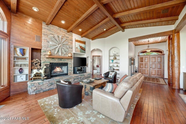 living room featuring hardwood / wood-style floors, high vaulted ceiling, built in features, a fireplace, and wood ceiling