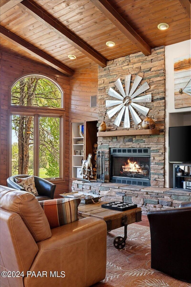 living room with lofted ceiling with beams, wood walls, a fireplace, and wood ceiling