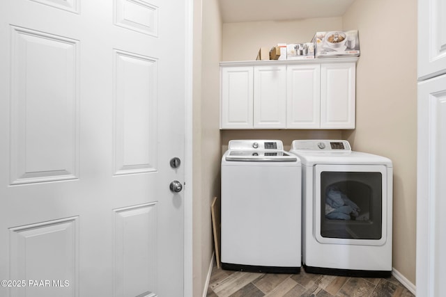 clothes washing area featuring washer and clothes dryer, dark hardwood / wood-style flooring, and cabinets