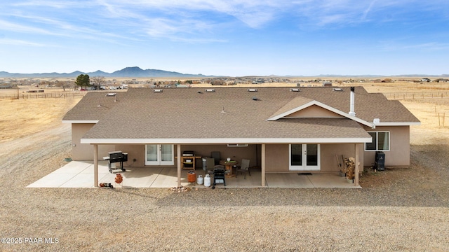 rear view of house with a mountain view, french doors, and a patio