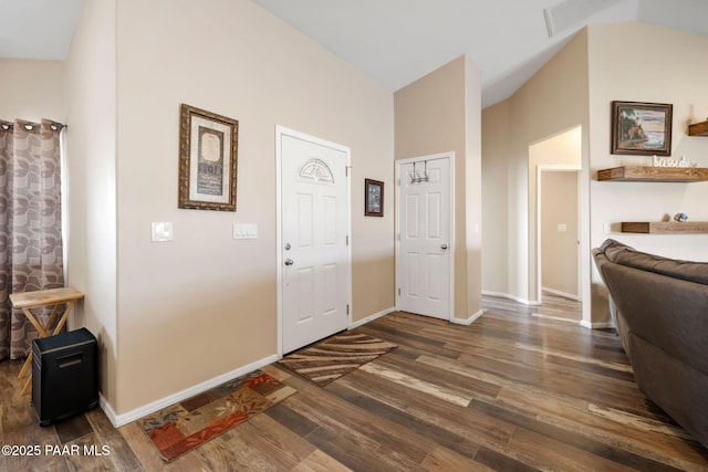 foyer with dark hardwood / wood-style flooring and vaulted ceiling