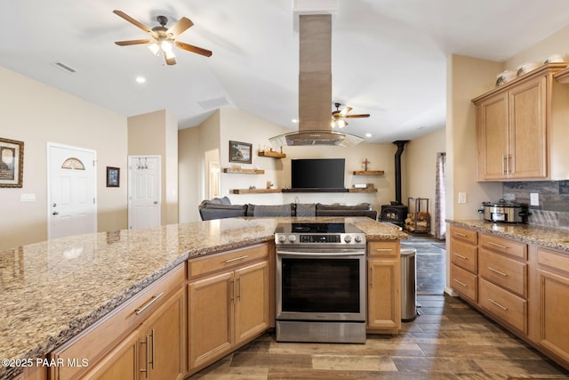 kitchen featuring a wood stove, electric stove, dark wood-type flooring, and island exhaust hood