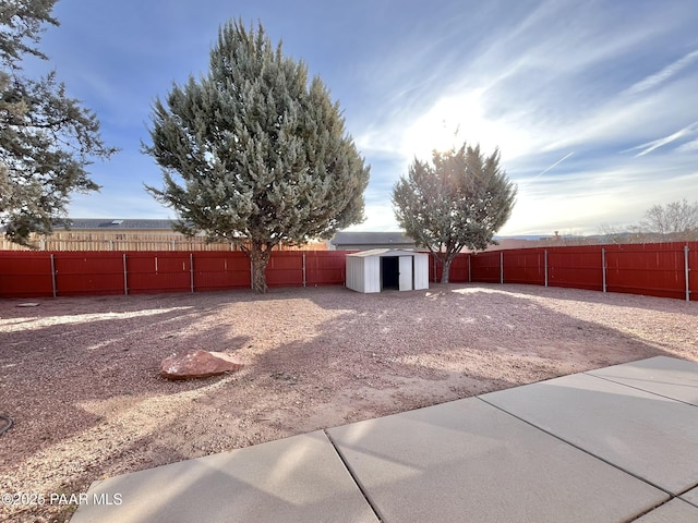 view of yard featuring a fenced backyard, a storage unit, and an outdoor structure