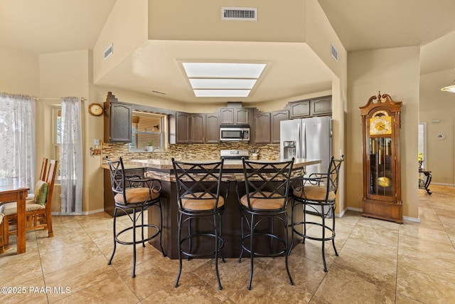 5278 N Saddleback Dr, Prescott Valley, AZ 86314 - kitchen featuring visible vents, a kitchen breakfast bar, tasteful backsplash, and stainless steel appliances