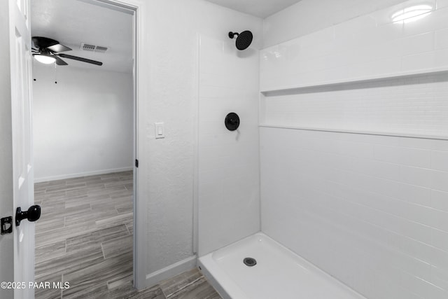 bathroom featuring ceiling fan and tiled shower