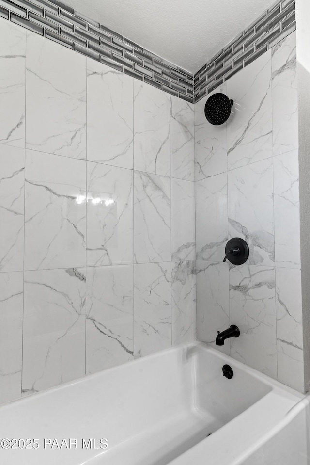 bathroom featuring tiled shower / bath