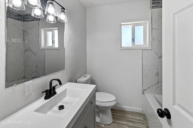 full bathroom with hardwood / wood-style floors, toilet, vanity, and tiled shower / bath combo