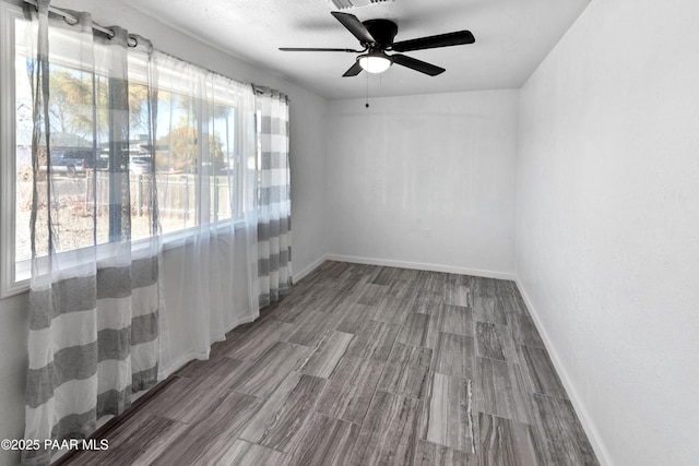 unfurnished room with ceiling fan and a textured ceiling