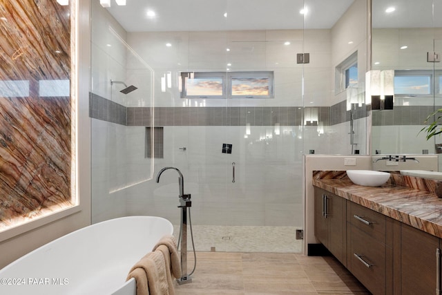 bathroom featuring tile patterned flooring, plenty of natural light, separate shower and tub, and vanity