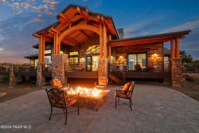 patio terrace at dusk featuring an outdoor fire pit