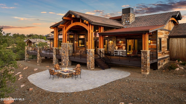 back house at dusk with a fire pit and a patio area