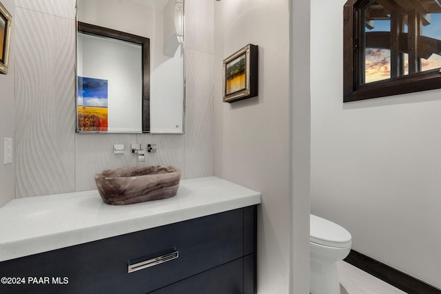 bathroom with tasteful backsplash, vanity, and toilet