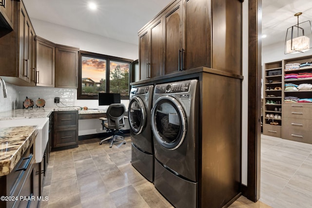 laundry room featuring washing machine and clothes dryer and cabinets