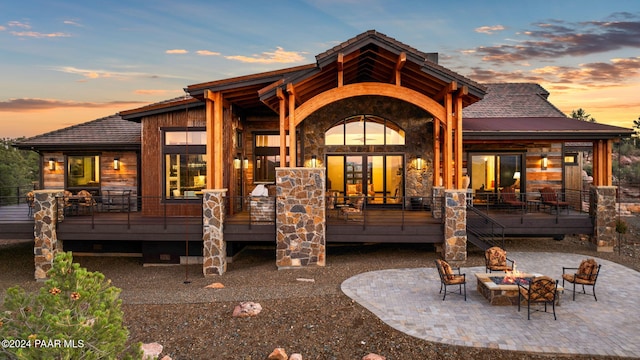 back house at dusk with a patio and a fire pit