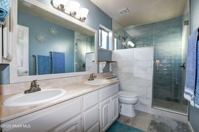 bathroom featuring vanity, a shower with shower door, and toilet