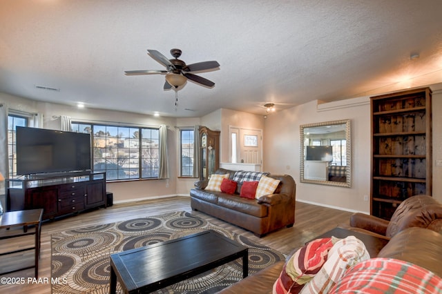 living room featuring ceiling fan, hardwood / wood-style floors, and a textured ceiling