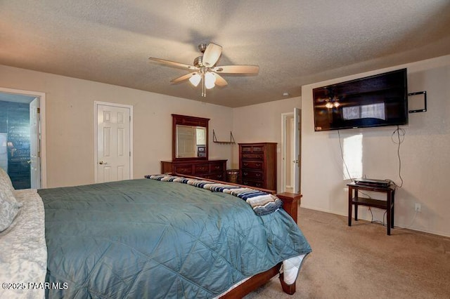 carpeted bedroom with ensuite bathroom, a textured ceiling, and ceiling fan