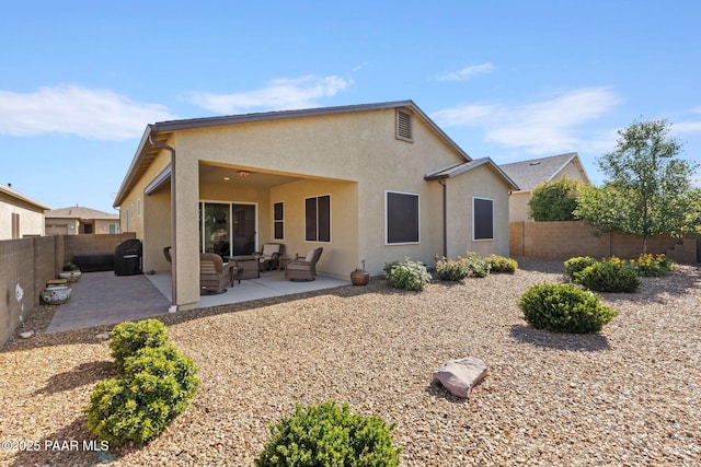12691 E De La Cruz St, Dewey-Humboldt, AZ 86327 - back of property featuring outdoor lounge area, stucco siding, a patio area, and a fenced backyard