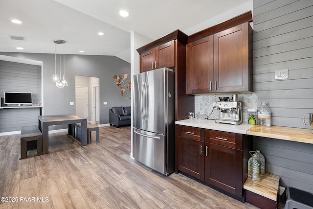 7921 E Las Palmas Dr, Prescott Valley, AZ 86314 - kitchen with freestanding refrigerator, lofted ceiling, light countertops, light wood-type flooring, and decorative backsplash