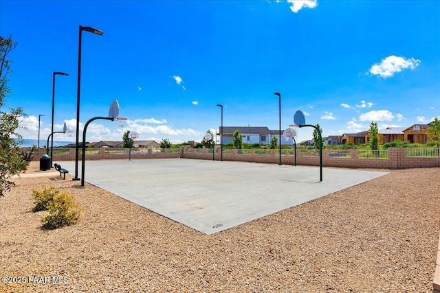 view of sport court featuring fence, community basketball court, and a residential view