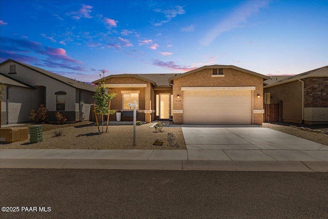 single story home with an attached garage, stucco siding, and driveway