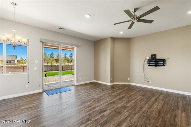 unfurnished room featuring recessed lighting, visible vents, dark wood-type flooring, baseboards, and ceiling fan with notable chandelier