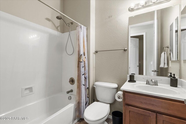 bathroom with vanity, toilet, a textured wall, and shower / bath combo with shower curtain