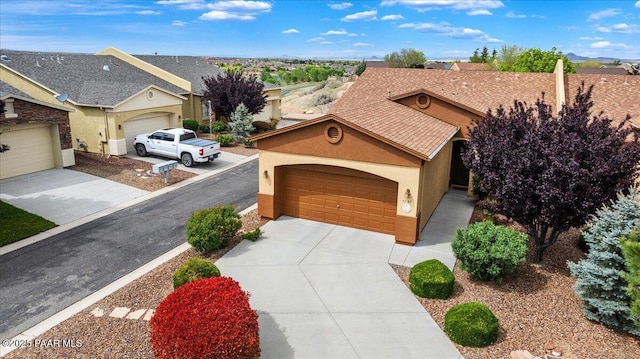 exterior space featuring concrete driveway, an attached garage, and stucco siding