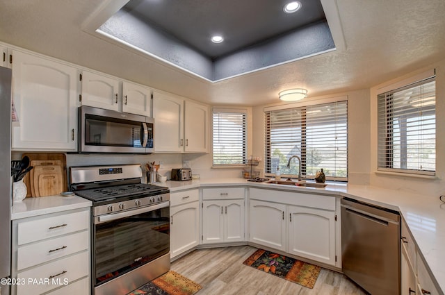 3096 Montana Dr, Prescott, AZ 86301 - kitchen featuring appliances with stainless steel finishes, a sink, light countertops, light wood-style flooring, and white cabinetry