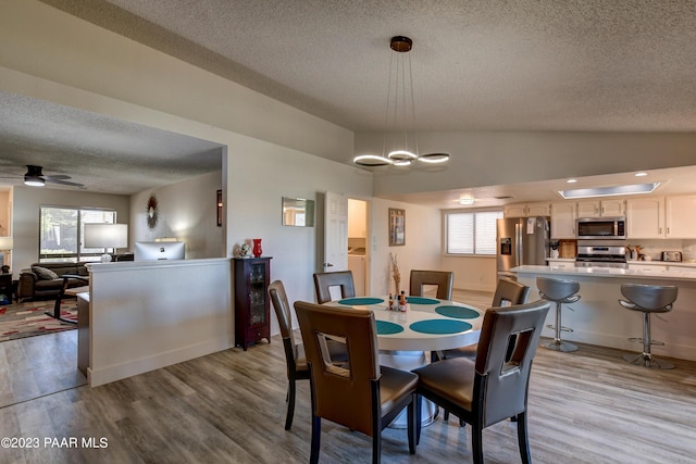 3096 Montana Dr, Prescott, AZ 86301 - dining area with a textured ceiling, vaulted ceiling, wood finished floors, and ceiling fan with notable chandelier