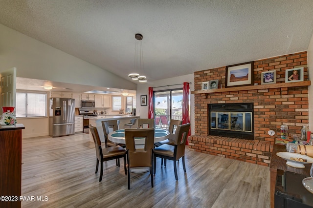 3096 Montana Dr, Prescott, AZ 86301 - dining space with light wood-type flooring, baseboards, a brick fireplace, and lofted ceiling