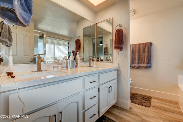 3096 Montana Dr, Prescott, AZ 86301 - bathroom featuring double vanity, wood finished floors, toilet, baseboards, and a sink