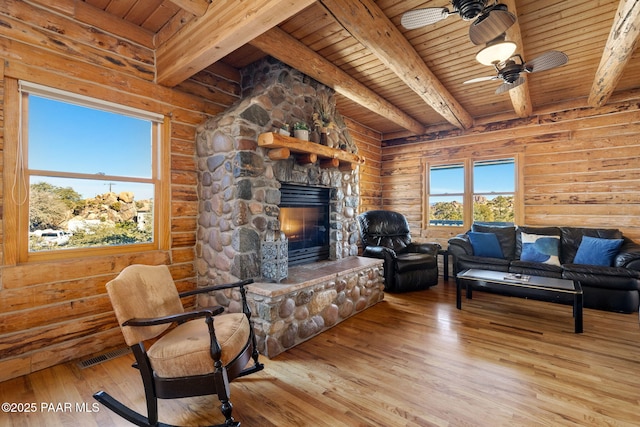 living room featuring wood ceiling, a fireplace, light hardwood / wood-style floors, and beamed ceiling