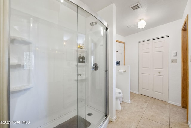 bathroom with an enclosed shower, tile patterned floors, and toilet