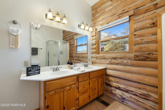 bathroom featuring a shower with door, vanity, tile patterned flooring, and rustic walls