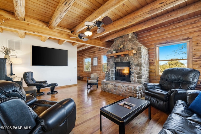 living room featuring wood ceiling, hardwood / wood-style flooring, a stone fireplace, and rustic walls