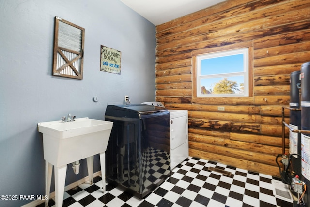 laundry area featuring rustic walls, separate washer and dryer, and gas water heater