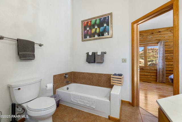 bathroom featuring toilet, tile patterned floors, a tub, and rustic walls