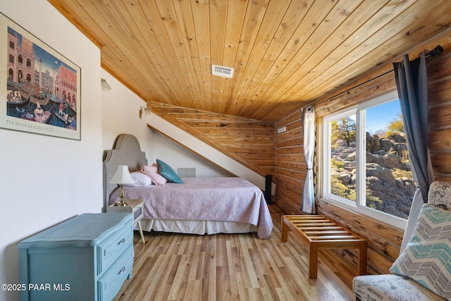 bedroom featuring log walls, light hardwood / wood-style floors, and wood ceiling