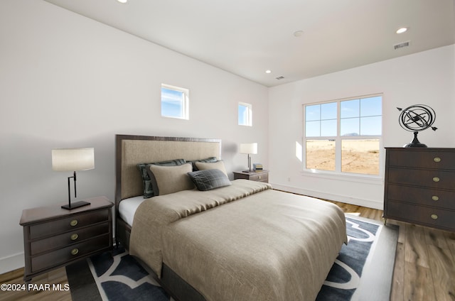 bedroom with hardwood / wood-style floors and multiple windows