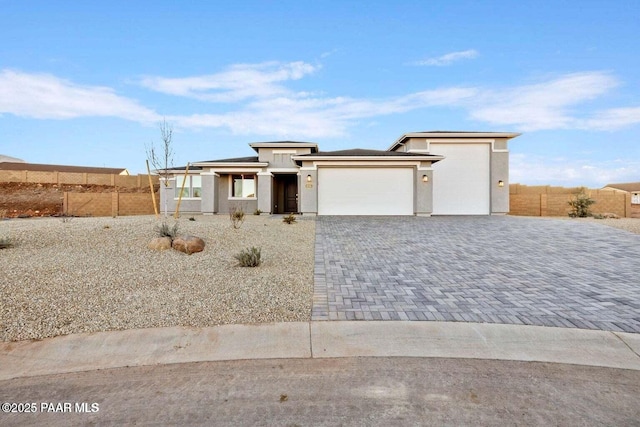 8595 N Isabella Ct, Prescott Valley, AZ 86315 - prairie-style house with a garage, stucco siding, decorative driveway, and fence