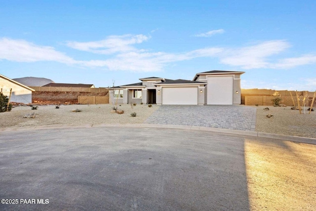 8595 N Isabella Ct, Prescott Valley, AZ 86315 - prairie-style house featuring a garage, stucco siding, fence, and decorative driveway