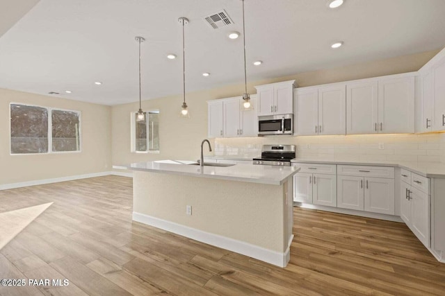 8595 N Isabella Ct, Prescott Valley, AZ 86315 - kitchen with light wood-type flooring, stainless steel appliances, visible vents, and backsplash