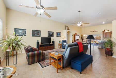 living room featuring light tile patterned flooring, lofted ceiling, and ceiling fan