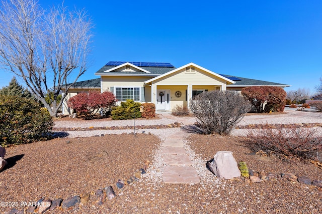 ranch-style home featuring covered porch and solar panels