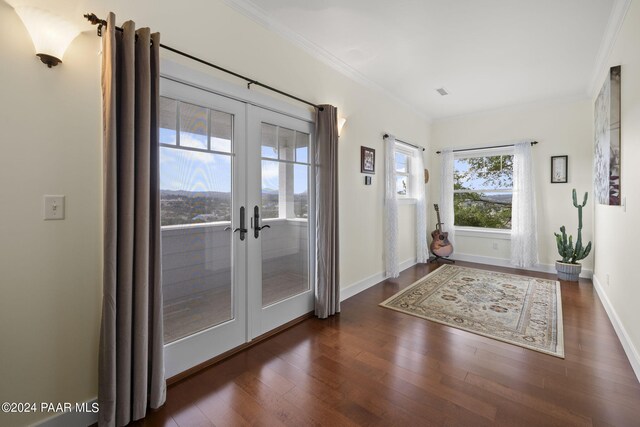 doorway featuring baseboards, ornamental molding, dark wood finished floors, and french doors