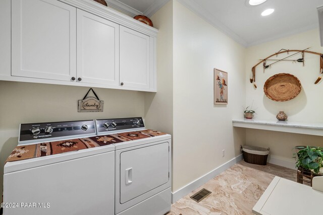 clothes washing area with separate washer and dryer, visible vents, baseboards, ornamental molding, and cabinet space